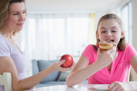 Caucasian mother offering daughter healthy food