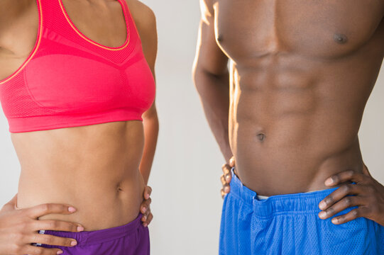 Close up of abdominals of athletic couple wearing sportswear