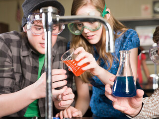 Students performing experiment in science lab classroom