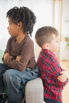 Boys arguing on living room sofa