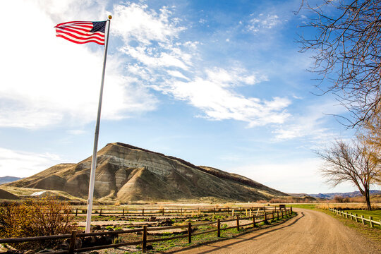 Low angle view of American flag over dirt road, Painted Hills, Oregon, United States