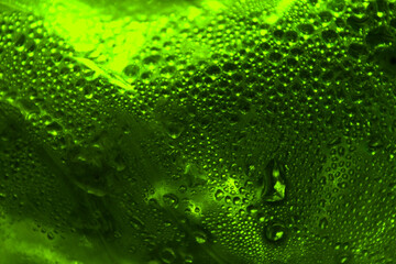 Bright green background. Drops of water on the surface. Juicy saturated background.