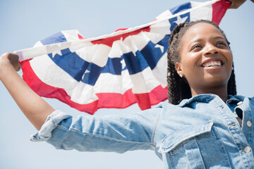 Black woman carrying American flag banner