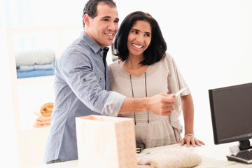 Hispanic couple paying at register