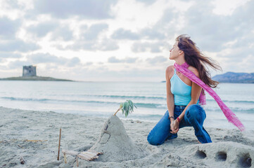 Caucasian woman building sandcastle on beach
