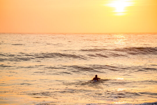 Caucasian surfer swimming in waves