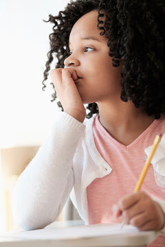 African American student writing in classroom
