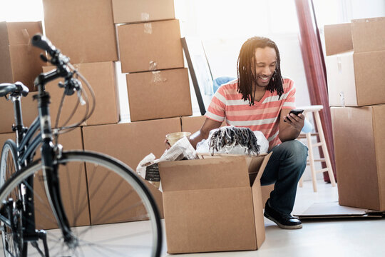 Black man unpacking boxes in new home