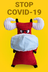 Bull symbol of 2021 in a medical mask on a yellow background. the inscription stop coronavirus