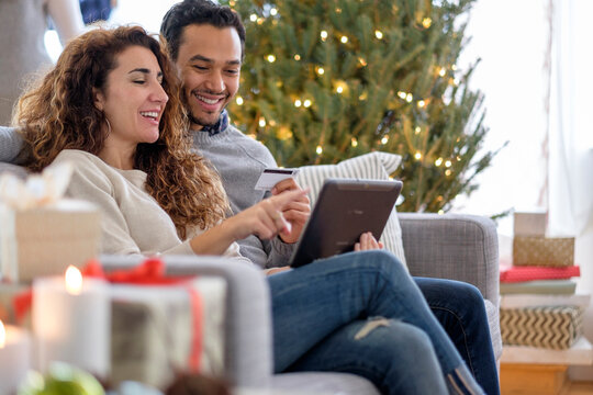 Couple shopping with digital tablet on sofa