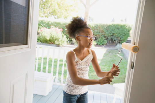 Mixed race girl painting doorway