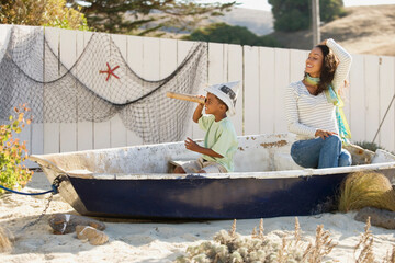 Mixed race mother and son pretending to sail in a boat