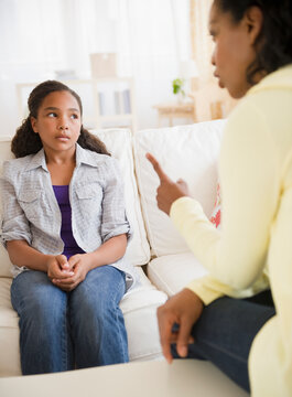 Mother lecturing daughter in living room