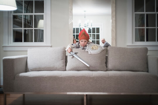 Fototapeta Caucasian boy playing with toy sword in living room