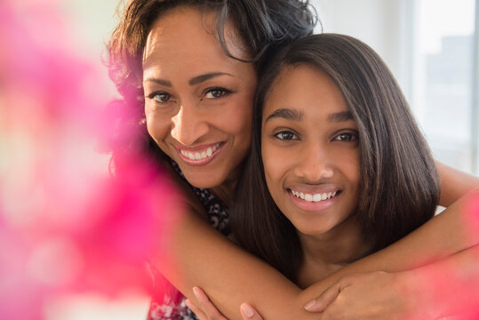 Smiling mother and daughter hugging