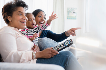 Black multi-generation family watching exciting television