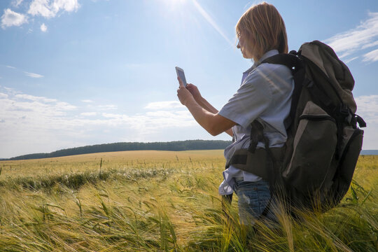 Caucasian woman standing in field using cell phone