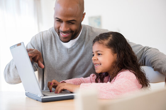 Father and daughter using laptop