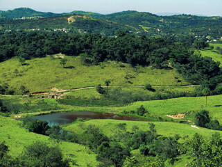 Linda vista de cima de montanha em final de tarde ensolarada, de fazenda situada na região de...