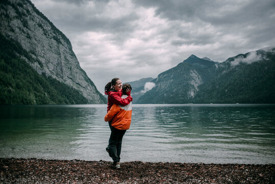 Caucasian man hugging near mountain lake