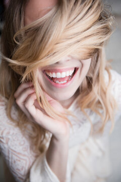 Laughing Caucasian woman covering eyes with hair
