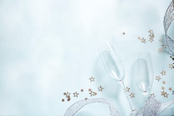 two champagne glasses and silver stars on light blue background. Valentine'd day, wedding, christmas greeting card concept