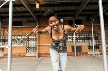Smiling African American woman dancing under scaffolding