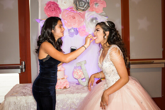 Hispanic girl feeding cookie to friend