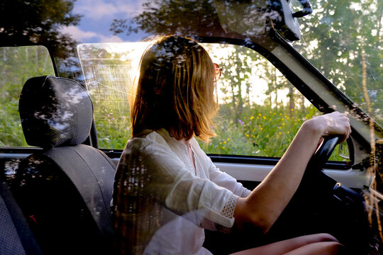 Woman driving car near forest