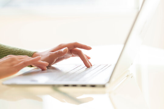 Hands typing on laptop keyboard