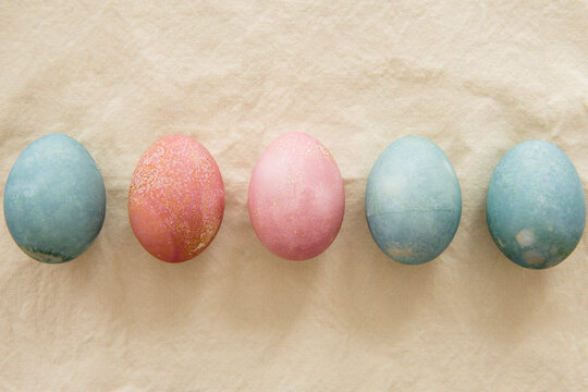 Dyed Easter eggs in a row on beige