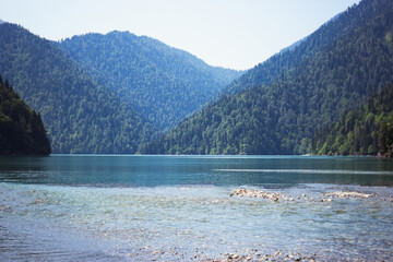 Beautiful nature, tourism, summer landscape, green grass and trees, river and mountains, lake