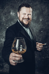 Solid smiling bearded man in suit with glass of whisky