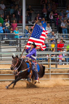 Woman on horse holding american flag