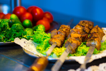 Tasty kebab on skewer with vegetables close up view.