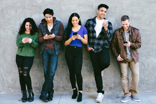 Friends standing next to each other and staring at their cell phones - No Communication - Texting - Games