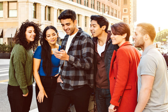 Group of young adults stand and wait for their ride - App - Ride Share - Urban