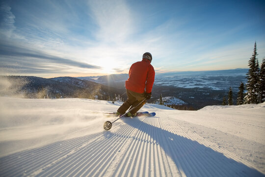 Mature man on ski slope at sunset