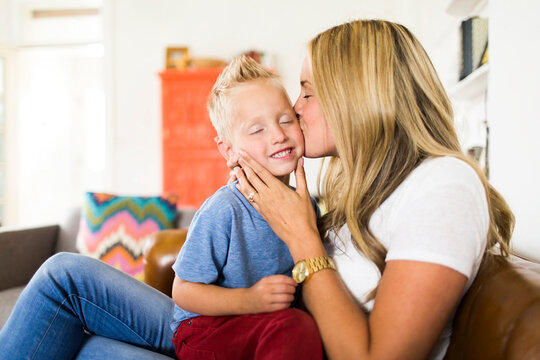 Mother kissing son (4-5)