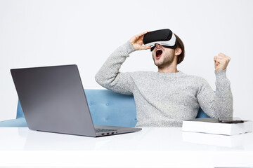 Portrait of beautiful man in glasses of virtual reality. Augmented reality. VR. Social media influencers or content maker concept. Guy browsing internet on computer and expresses emotions.