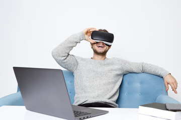 Portrait of beautiful man in glasses of virtual reality. Augmented reality. VR. Social media influencers or content maker concept. Guy browsing internet on computer and expresses emotions.