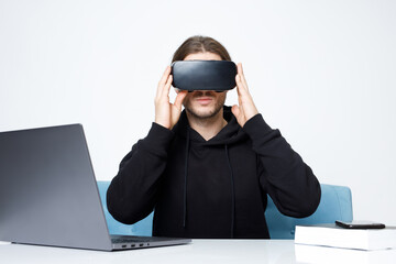 Portrait of beautiful man in glasses of virtual reality. Augmented reality, future technology concept. VR. Guy browsing internet on computer and expresses emotions.