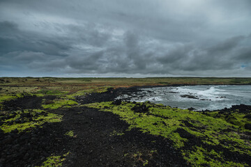 a rocky beach with a cloudy sky