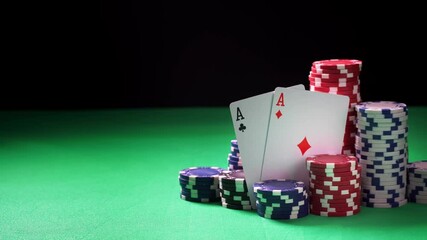 Stacks of poker chips and two aces on green table and black background in close-up. Concept of playing hazard games in casino. Winning and losing money theme. Gambling as entertainment at leisure time - Powered by Adobe