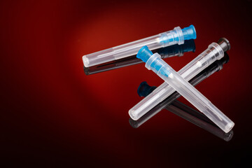 group of syringe needles over dark red background. copy space. vaccination concept