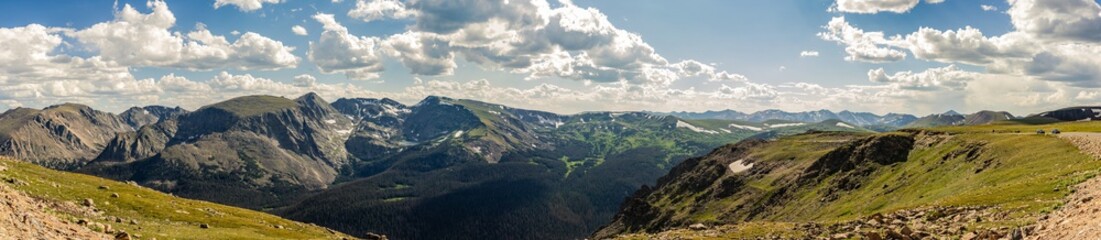 Fototapeta premium Panorama shot of green rocky hills with remnants of snow in Rocky mountains national park in america