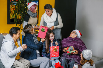 Fototapeta premium three generations of Latin women celebrating Christmas at home in Mexico