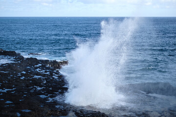 a rocky beach with waves crashing against it