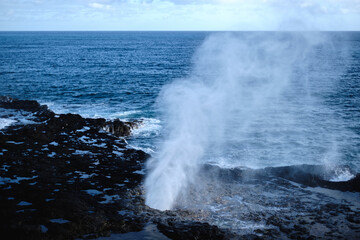 a large wave crashing into rocks