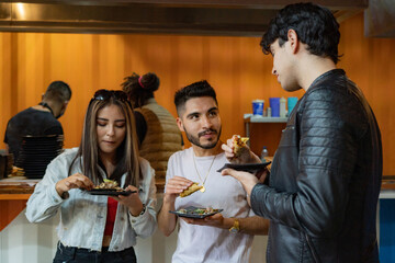 friends eating tacos at night in a street business